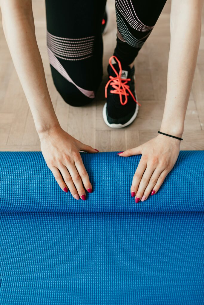 Deux mains enroulent un tapis de yoga